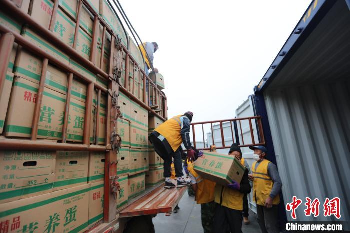 圖為鐵路裝卸作業(yè)人員正在將云南特色農(nóng)產(chǎn)品裝入集裝箱?！詈?攝