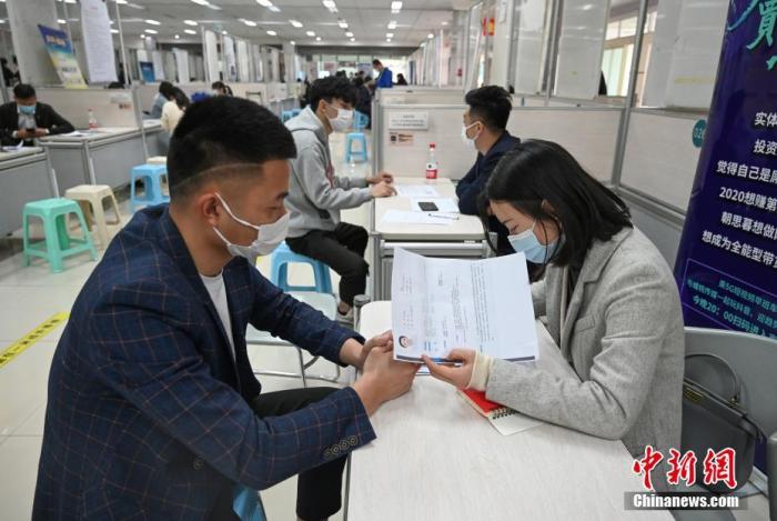 4月14日，招聘者在查看求職者簡(jiǎn)歷。<a target='_blank'  data-cke-saved- >中新社</a>記者 王剛 攝