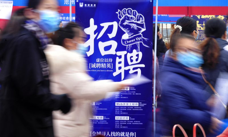 求職者從一家招聘企業(yè)的廣告牌前走過(guò)。新華社發(fā)（苑立偉 攝）