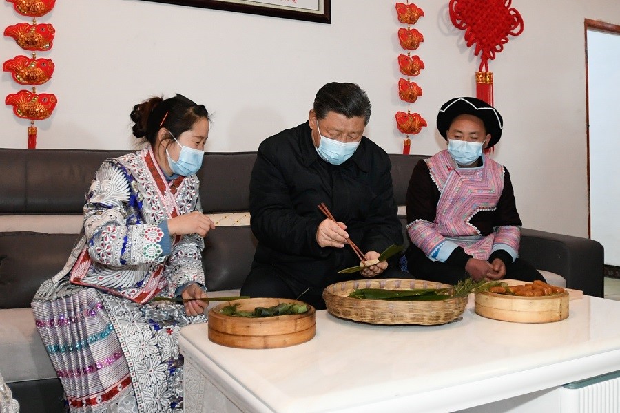 2021年2月3日下午，習(xí)近平在貴州畢節(jié)市黔西縣新仁苗族鄉(xiāng)化屋村苗族村民趙玉學(xué)家，同一家人邊聊家常邊制作當(dāng)?shù)貍鹘y(tǒng)節(jié)日食品黃粑。新華社記者 李學(xué)仁 攝